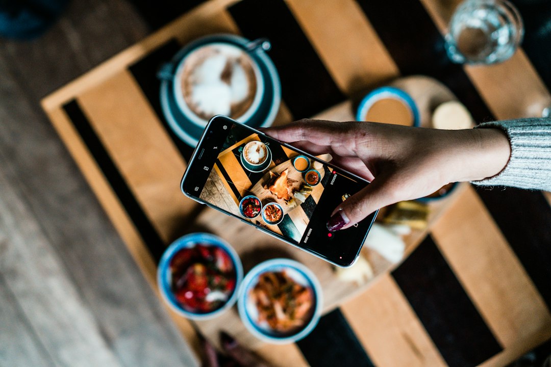 Personne photographiant un plat pour les réseaux sociaux