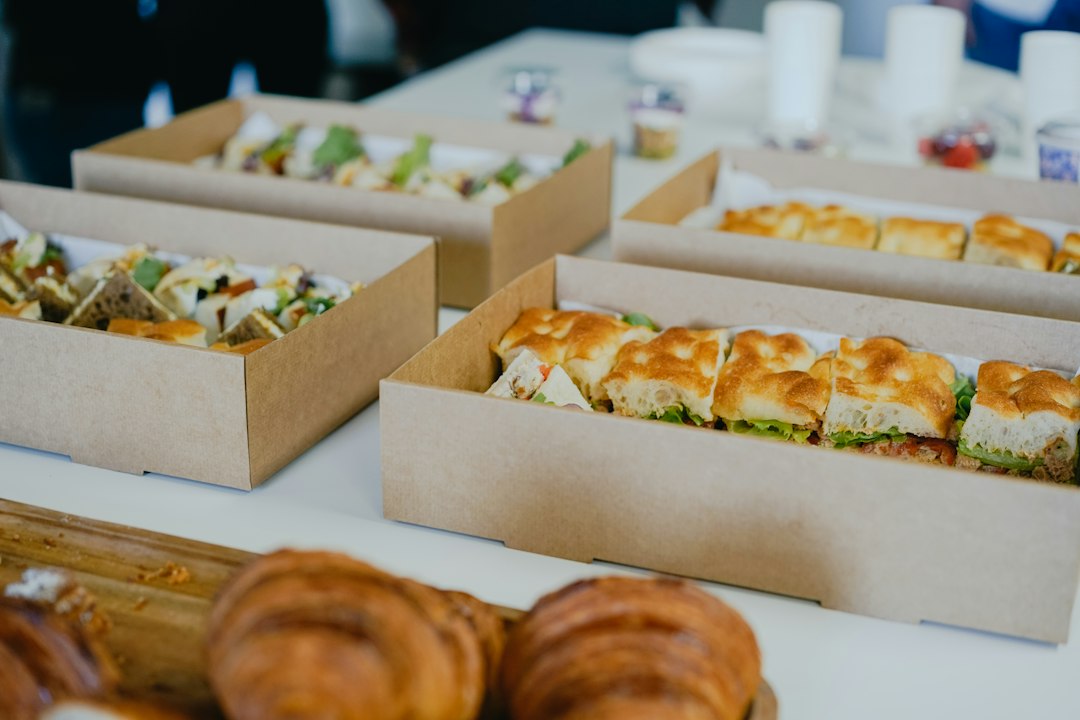 Boîtes de plateaux repas et viennoiseries disposées sur une table pour une livraison d'entreprise