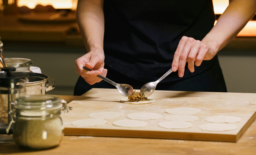 Mains remplissant des cercles de pâte dans un atelier