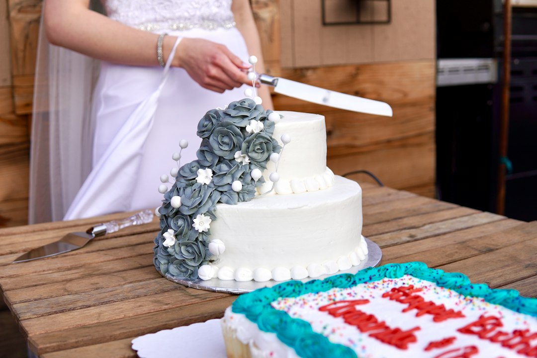 Des mariés coupent un wedding cake à plusieurs étages