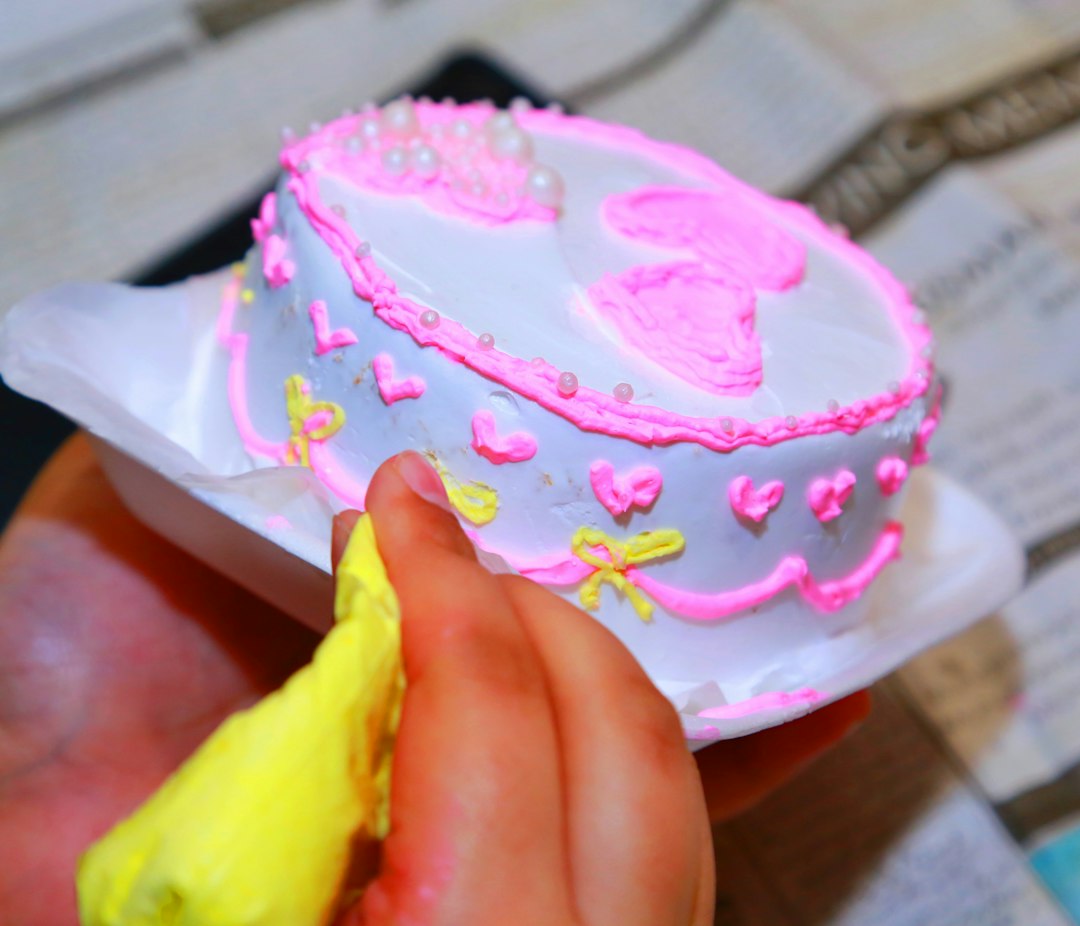 Main décorant un gâteau à la poche à douille