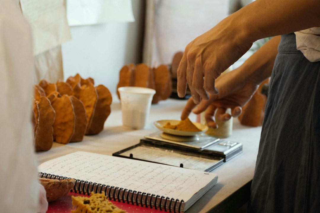 Mains pesant des ingrédients sur une balance de cuisine